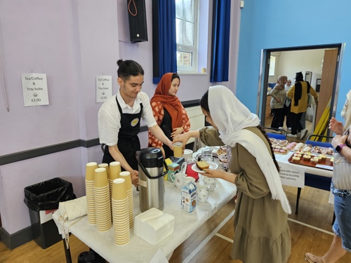 Young people from the Extern refugee barista academy serving coffee at the summer fair