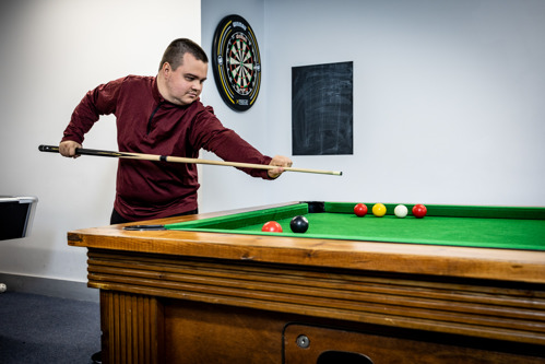 Young service user playing pool